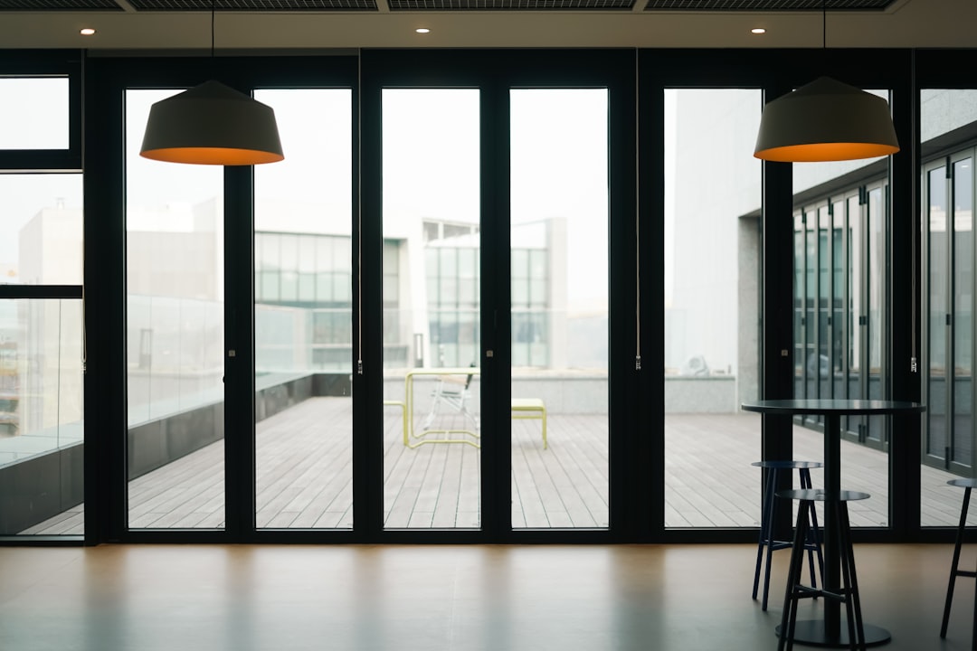 a-room-with-a-table-chairs-and-a-large-window-cvppgx1xxzq